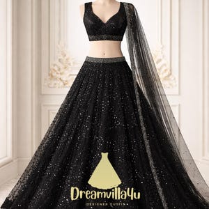 May include: A black formal gown with a matching top and skirt, displayed on a mannequin. The outfit features a V-neck top and a full skirt, both embellished with sparkling details. A sheer, matching scarf drapes over the shoulder. The text "Dreamvilla4u DESIGNER OUTFITS" is visible.