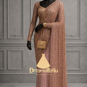 Könnte beinhalten: Ein bodenlanges, roségoldenes Kleid mit langen Ärmeln und einem V-Ausschnitt. Das Kleid ist stark mit Pailletten und Perlen verziert. Eine passende, mit Perlen besetzte Handtasche hängt am Arm der Schaufensterpuppe. Das Kleid wird auf einer schwarzen Schaufensterpuppe präsentiert. Der Markenname "Dreamvillalu" ist sichtbar.