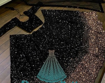 Può includere: Una gonna di paillettes nera e dorata con un top nero abbinato e una dupatta nera trasparente. La gonna presenta un effetto sfumato, passando dal nero all'oro. Il tessuto è decorato con paillettes.