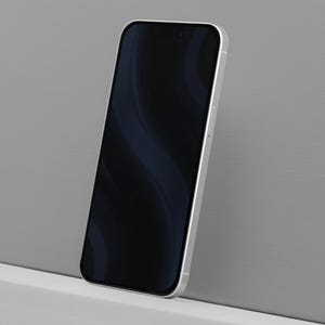 May include: A silver smartphone with a black screen displaying a dark blue wavy pattern. The phone is leaning against a gray wall, showcasing its sleek design. The screen is black with a dark blue wavy pattern.