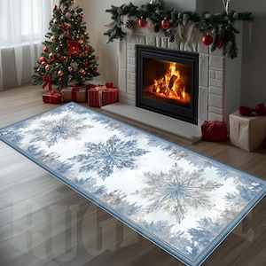 May include: A rectangular rug with a snowflake pattern in shades of blue and gray. The rug has a blue border and is placed on a wooden floor in front of a fireplace and Christmas tree. The room is decorated for the holidays.