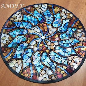 May include: A circular stained glass mosaic with a colourful design. The mosaic features a variety of colours, including blue, green, red, and yellow. The mosaic is made up of small, individual pieces of glass that are arranged in a geometric pattern.