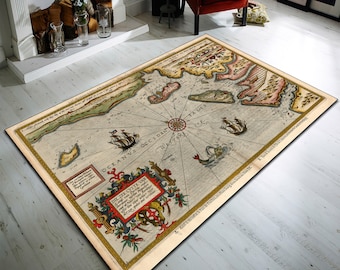 May include: An antique-style rug featuring a detailed map of a coastal region. The map is surrounded by a decorative border with a compass rose and a coat of arms. The rug is beige with brown, red, and blue accents.