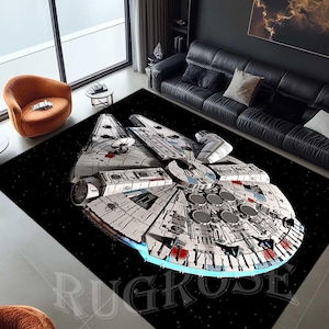 Könnte beinhalten: Ein schwarz-weißer Teppich mit einem detaillierten Bild des Raumschiffs Millennium Falcon aus Star Wars. Der Teppich hat einen schwarzen Hintergrund mit weißen Sternen und das Raumschiff befindet sich in der Mitte des Teppichs.