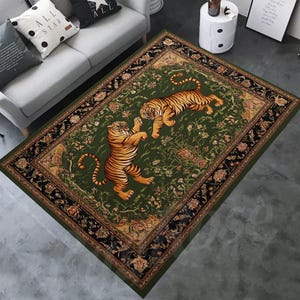 May include: A rectangular green rug featuring two orange and black striped tigers. The rug has a floral pattern and a black border with gold accents. The rug is placed on a gray floor.