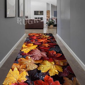 Puede incluir: Una alfombra de pasillo rectangular larga con un estampado de alta definici&oacute;n de hojas de oto&ntilde;o ca&iacute;das en tonos amarillos, naranjas, rojos y marrones. Las hojas est&aacute;n cubiertas de gotas de agua realistas, creando un revestimiento de suelo estacional.