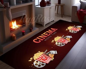 May include: A red and brown rectangular rug with the text "CINEMA MOVIE TIME" in white. The rug features three illustrations of popcorn buckets, film reels, and tickets.