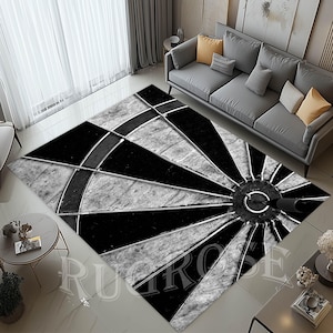 Könnte beinhalten: Schwarz-weißer Teppich mit einem Dartboard-Design. Der Teppich hat einen Used-Look und zeigt einen schwarzen Dart in der Mitte.