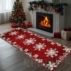 Puede incluir: Una alfombra rectangular roja con un diseño de copos de nieve. La alfombra tiene grandes copos de nieve blancos y puntos blancos más pequeños sobre un fondo rojo. La alfombra está en un salón con un árbol de Navidad y una chimenea.