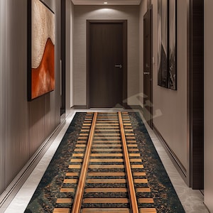 May include: A hallway runner rug featuring a detailed railway track design. The rug has a dark, textured background with parallel wooden rails and evenly spaced wooden sleepers. The runner is placed in a modern hallway with dark wood paneling and a marble floor.