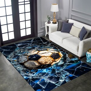 May include: A blue and black area rug with a cracked glass design. A worn soccer ball is in the center of the rug.