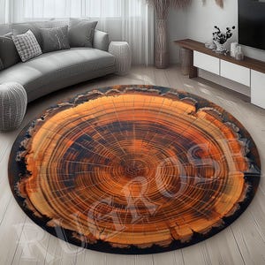 May include: A round rug with a wood grain pattern that resembles a tree trunk cross-section. The rug has a dark brown border and a light brown center with concentric rings.