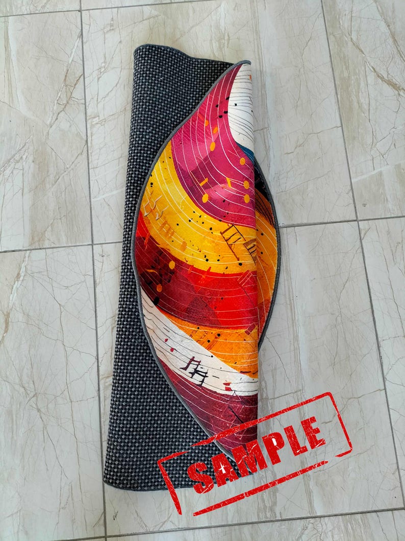 May include: A rolled up round rug with a colorful abstract design featuring musical notes and a black border. The rug is labeled "SAMPLE".