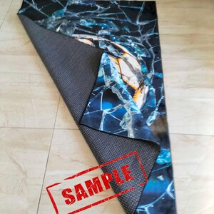 May include: A blue and black rug with a cracked glass design. The rug has a non-slip backing and is labeled "SAMPLE".