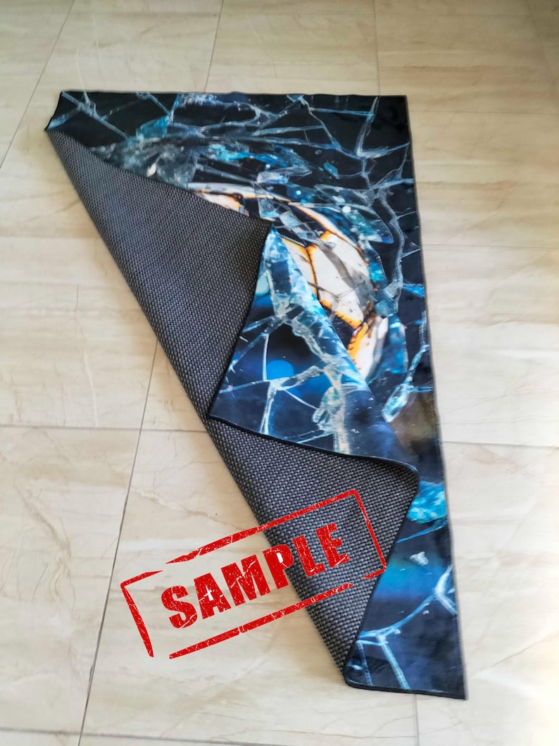 May include: A blue and black rug with a cracked glass design. The rug has a non-slip backing and is labeled "SAMPLE".