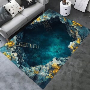 May include: Area rug with a digitally printed design of a deep blue pool with ladders. The rug features gold and white accents, creating a textured, artistic look. The rug is rectangular and suitable for a living room or bedroom.