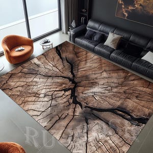 Puede incluir: Una alfombra marrón y negra con un patrón de veta de madera. La alfombra tiene un aspecto desgastado y presenta un gran diseño circular que se asemeja a un tocón de árbol.