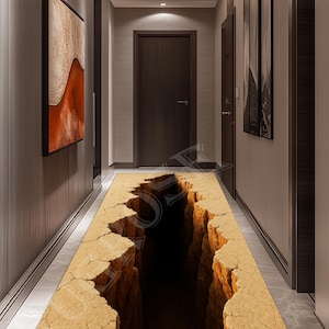 Könnte beinhalten: Ein Flurläufer-Teppich mit einer 3D-Grafik eines tiefen Canyons. Der Teppich zeigt eine realistische Darstellung eines rissigen, hellbraunen Canyonbodens mit dunklen Schatten. Der Teppich befindet sich in einem Flur mit dunklen Holztüren und -verkleidungen.