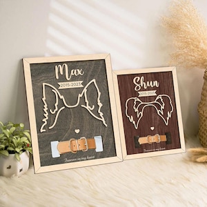 May include: Two wooden pet memorial plaques with a dog silhouette, collar, and dates. The plaque on the left is brown with the name Max and the dates 2015-2023. The plaque on the right is dark brown with the name Shun and the dates 2015-2023. Both plaques have the text "Forever in my heart".