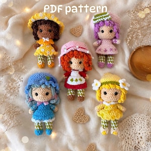 May include: Five crocheted dolls with yarn hair and outfits, including a yellow-hatted doll, a purple-haired doll, a red-hatted doll, a blue-hatted doll, and a yellow-haired doll. The text "PDF pattern" is visible at the top of the image.