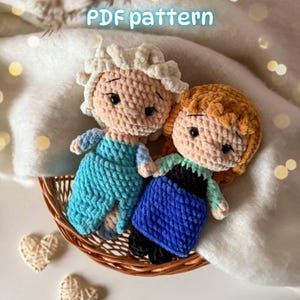Puede incluir: Dos muñecas tejidas a mano con textura de hilo de felpa. Una muñeca tiene cabello blanco y vestido azul claro, mientras que la otra tiene cabello castaño, corpiño negro y falda azul. El texto "PDF pattern" es visible en la parte superior.