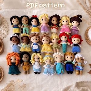 May include: A collection of twenty-one small crocheted dolls arranged in three rows, each featuring distinct yarn colours and outfits. The text "PDF pattern" is visible at the top. The dolls have yarn hair, embroidered facial features, and various dresses.