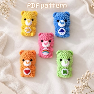May include: Five small crocheted bear figures in yellow, blue, pink, orange, and green, each with a white muzzle, black eyes, and a unique felt belly emblem. The text PDF pattern is displayed at the top of the image above the plush toys.