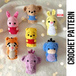 Könnte beinhalten: Eine Sammlung handgefertigter Häkelfiguren, darunter ein rosa Hase, ein brauner Bär, ein gelber Bär, ein gelbes Kaninchen, ein orangefarbener Tiger, ein blauer Hund und ein lila Elefant. Der Text "CROCHET PATTERN" wird vertikal rechts angezeigt.