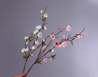 May include: A bouquet of artificial flowers with pink and white blossoms on brown stems. The flowers are arranged in a cluster and have a realistic appearance.