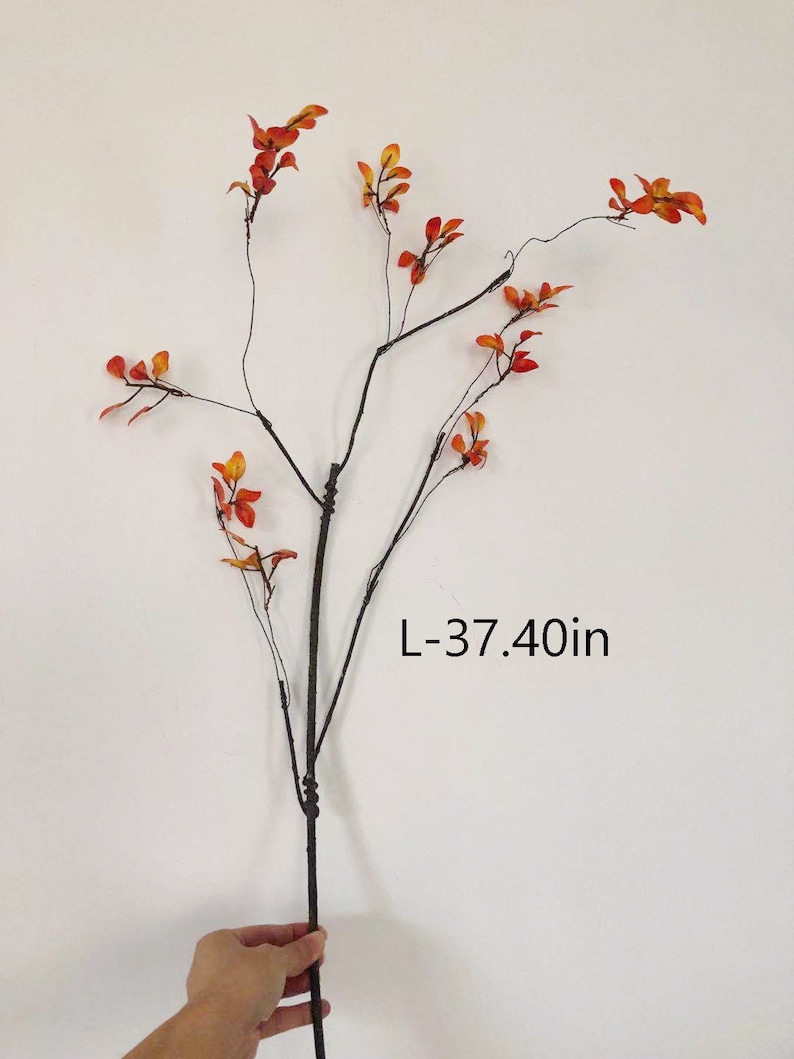 May include: A single artificial branch with brown stems and small orange leaves. The branch is 37.40 inches long.