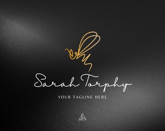 Può includere: Un'illustrazione di un'ape dorata con una firma in corsivo bianco che recita "Sarah Torphy" e il testo "YOUR TAGLINE HERE" sotto. Un piccolo triangolo bianco con un contorno nero si trova nella parte inferiore dell'immagine.