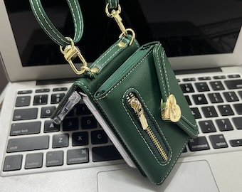 May include: A dark green leather wallet with a gold zipper and heart-shaped clasp. The wallet has a strap that can be used to carry it as a crossbody bag.