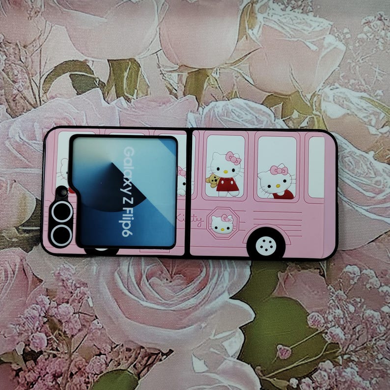 May include: A pink phone case with a Hello Kitty design. The case is a flip case with a window on the front that says "Galaxy Z Flip6".