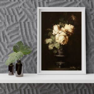 May include: A framed painting of a bouquet of white roses in a dark vase. The roses are arranged in a cluster and have a soft, delicate appearance. The vase is a dark, antique-looking piece with a rounded base and a narrow neck.