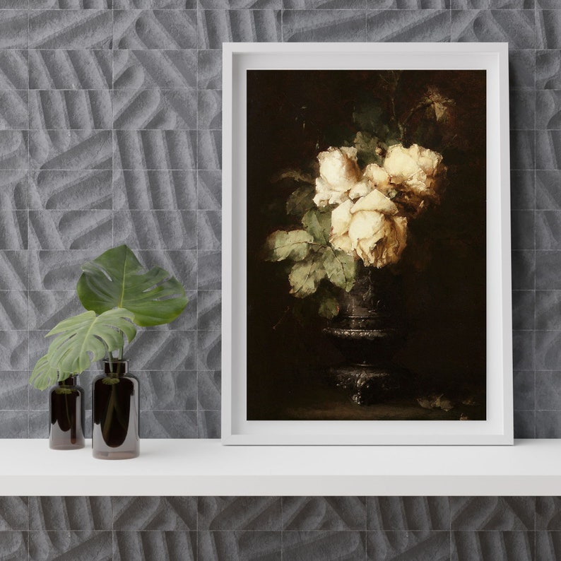 May include: A framed painting of a bouquet of white roses in a dark vase. The roses are arranged in a cluster and have a soft, delicate appearance. The vase is a dark, antique-looking piece with a rounded base and a narrow neck.