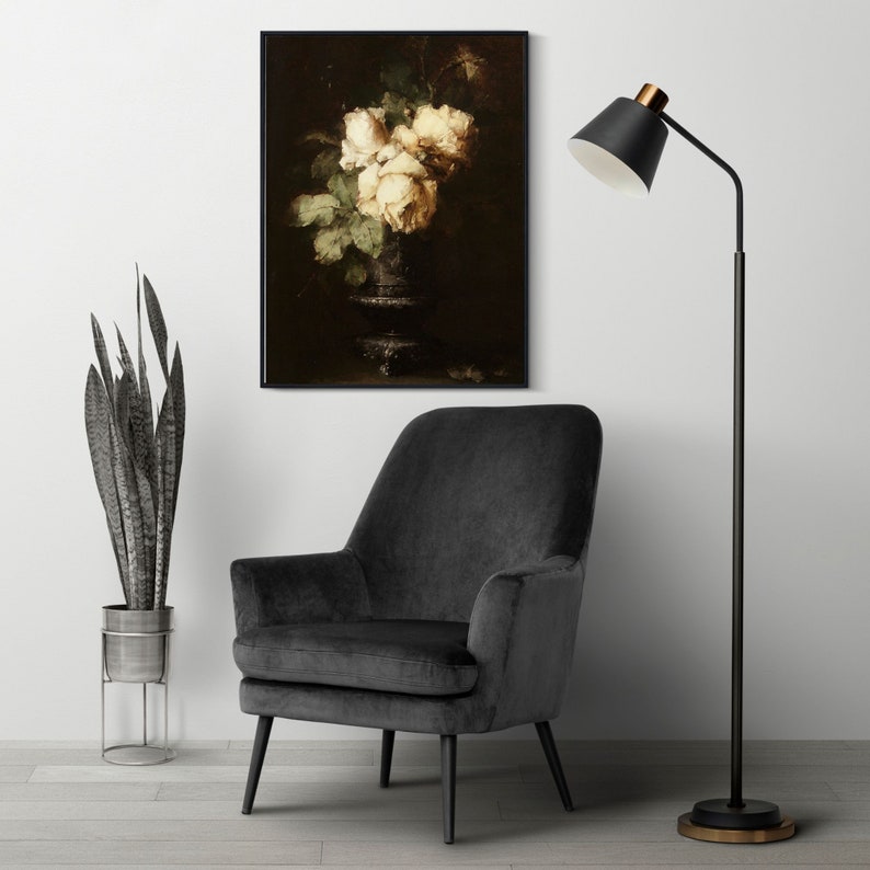 May include: A black and white still life painting of white roses in a vase. The painting is framed and hanging on a white wall. A black floor lamp with a gold accent is in the foreground.