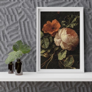 May include: A framed print of a still life painting featuring a pink rose and an orange poppy with green leaves on a dark background.