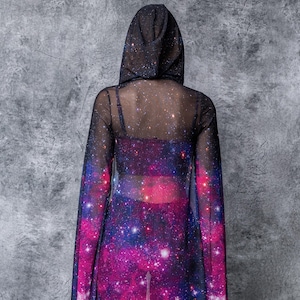 May include: A black mesh hooded top with a galaxy print. The top is sheer and has long sleeves.