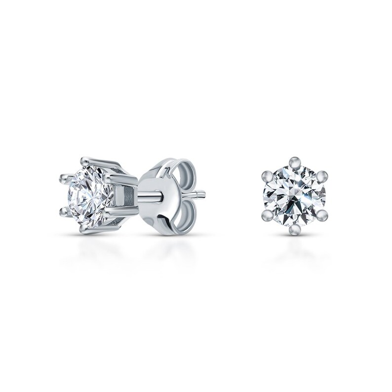 May include: A pair of silver stud earrings with a single round clear stone in each earring.