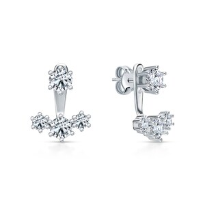 May include: A pair of silver earrings with a single large round clear stone on the top and three smaller round clear stones on the bottom.