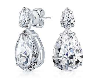 May include: A pair of silver teardrop earrings with clear crystal stones. The earrings have a dangling design with two stones on each earring.