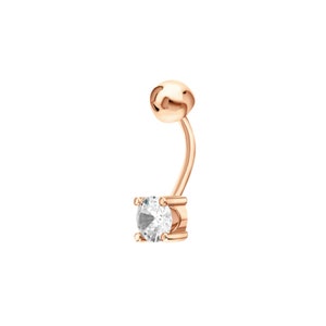 May include: A rose gold belly button ring with a clear round gemstone.