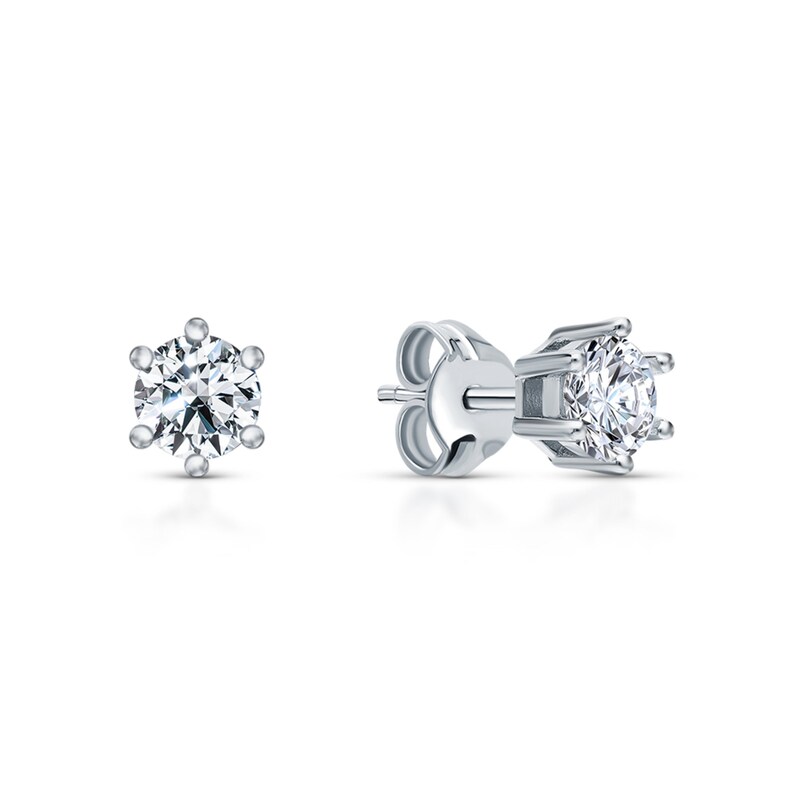 May include: A pair of silver stud earrings with a round, clear gemstone in the center.