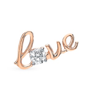 Könnte beinhalten: Eine Halskette mit einem Anhänger aus Roségold, auf dem das Wort "love" in Kursivschrift geschrieben ist. Ein kleiner, klarer Diamant ist in der Mitte des "o" eingesetzt.