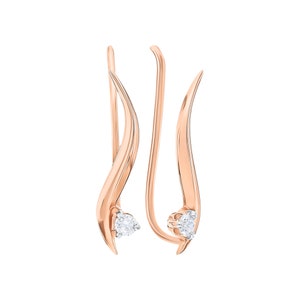 Può includere: Un paio di orecchini in oro rosa con un solo diamante su ogni orecchino. Gli orecchini hanno la forma di una linea curva.