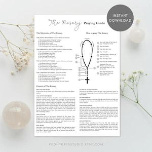 May include: A white informational sheet titled The Rosary Praying Guide featuring black text, a diagram of rosary beads with a cross, and lists of the Joyful, Sorrowful, Glorious, and Luminous Mysteries alongside various traditional Catholic prayers.