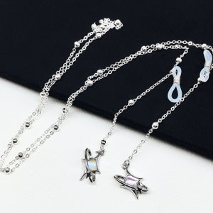 May include: Silver eyeglass chain with iridescent star-shaped charms and clear silicone ear hooks.