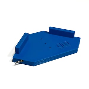 May include: A bright blue, geometric-shaped object with raised edges and a metal rod extending from one side. The object has a logo on the surface and is set against a white background.