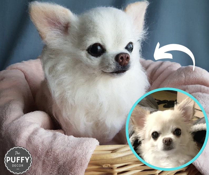 May include: A white Chihuahua dog sculpture with fluffy fur, a brown nose, and dark eyes, nestled in a pink basket. The image includes a smaller circular photo of the dog. The Puffy Decor logo is visible.