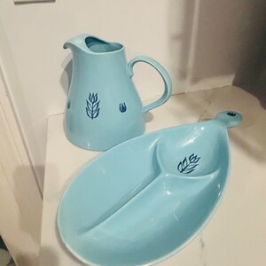 May include: A light blue ceramic pitcher and a matching divided serving dish with a wheat design. Both pieces have a blue wheat design.